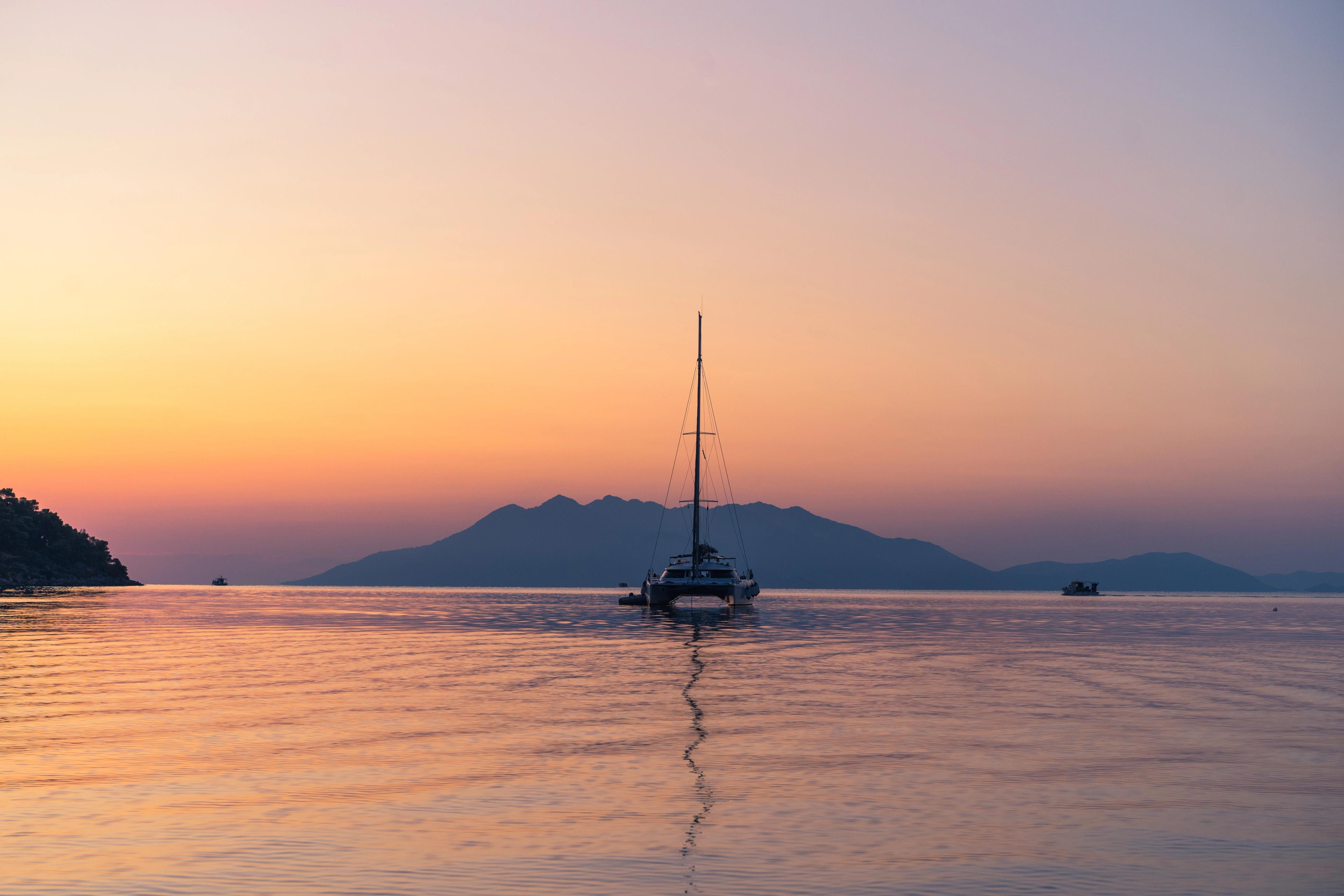 Scenic beautiful sunrise with a view on a boat at the marine of Epidaurus Island, Peloponnese, Saronic Gulf, Greece.