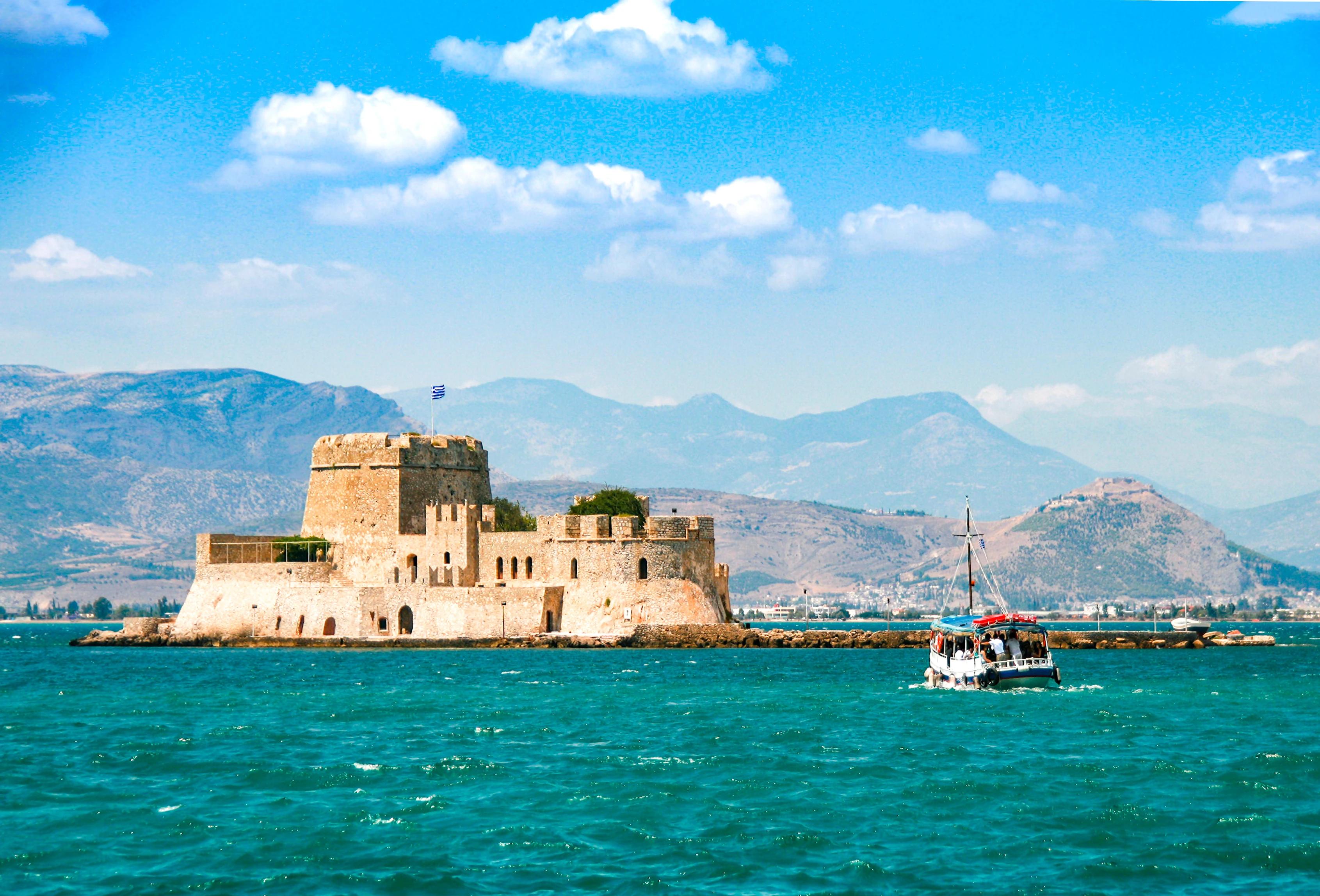 Small wooden boat transfer a group of tourists to Bourtzi island (an ancient prison). Nafplion , Greece