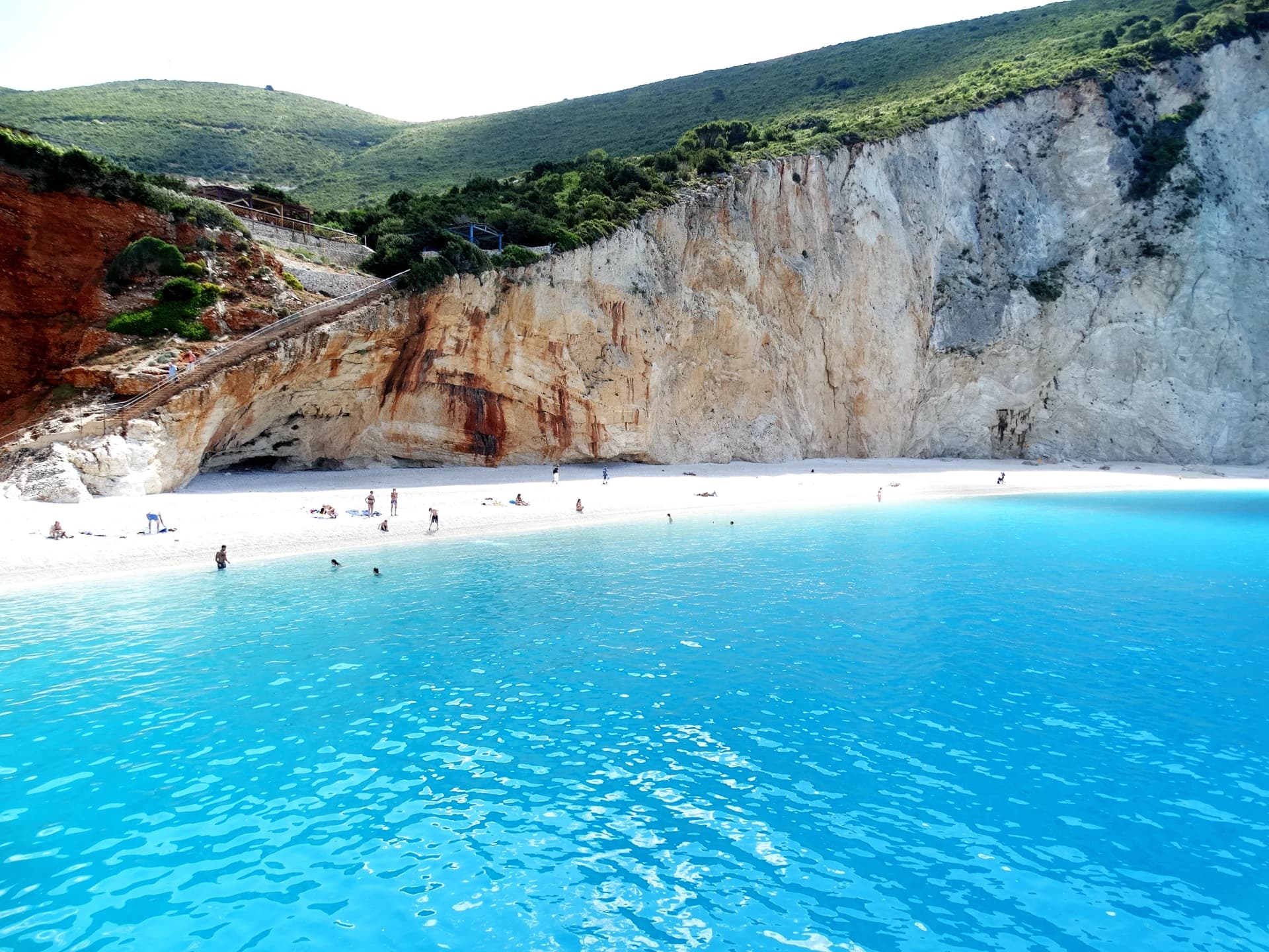 Porto Katsiki beach natural landscape and seascape with island, cliff, rock, plant, sea cave, blue sky, and sunray. Travel destination in western Greece of Ionian Islands, Lefkas, Kefalonia, Meganisi