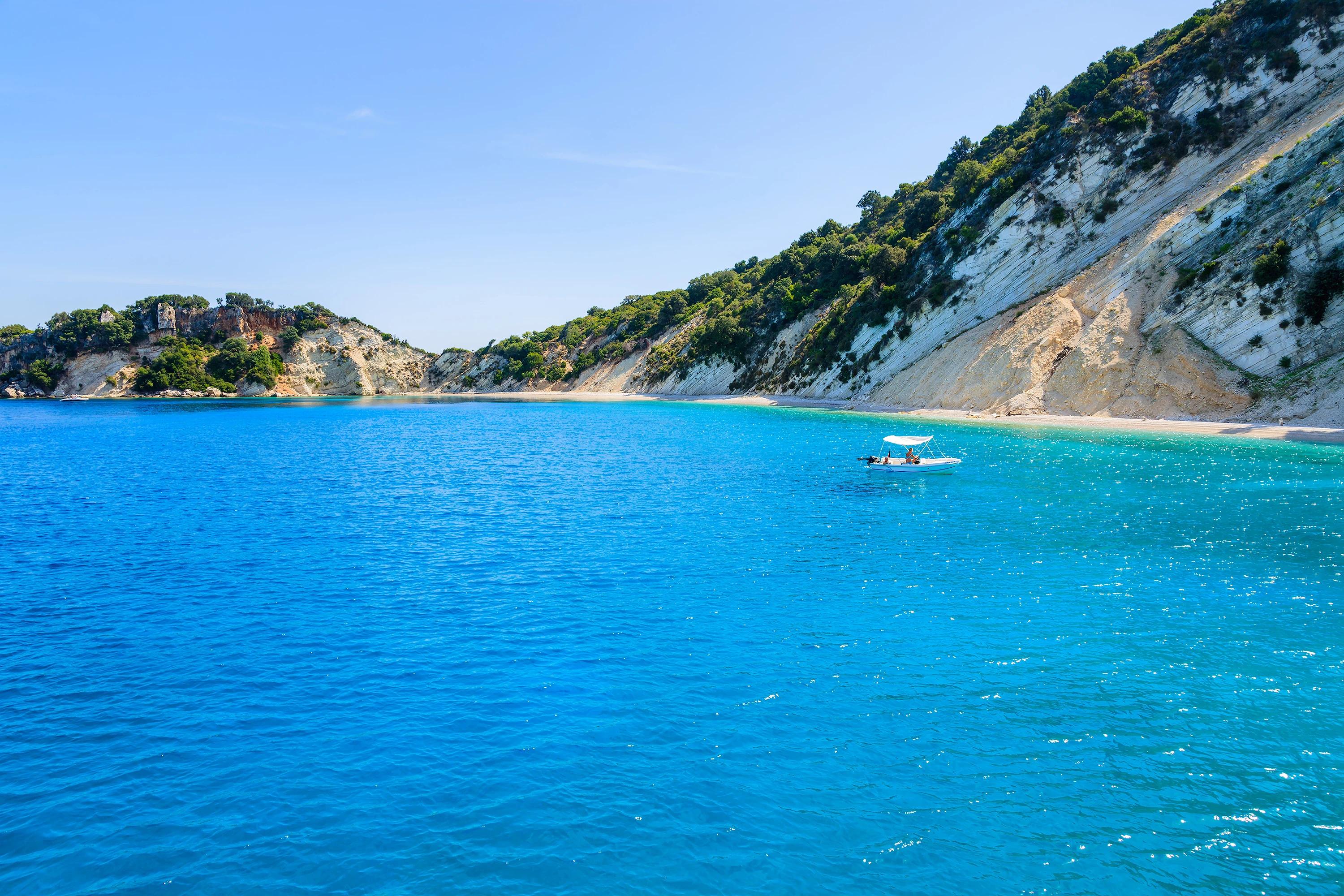 Small boat on azure sea near beautiful beach on Ithaka island